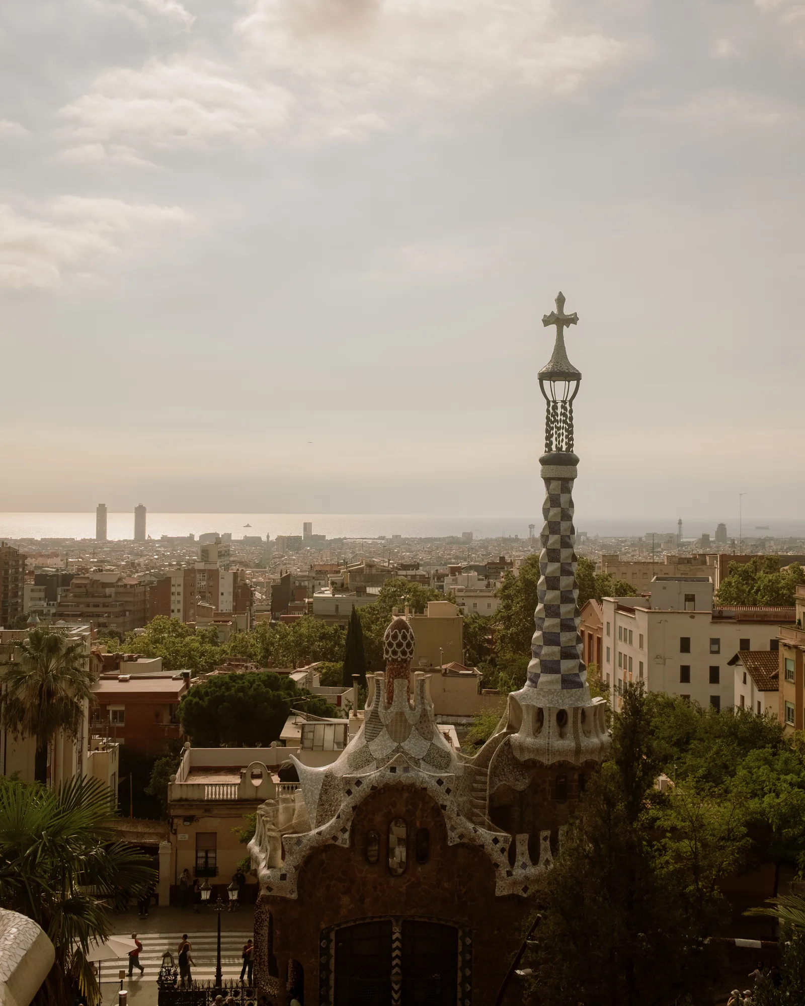 Barcelona skyline from Park Güell with the checkered gatehouse tower and the sea beyond
