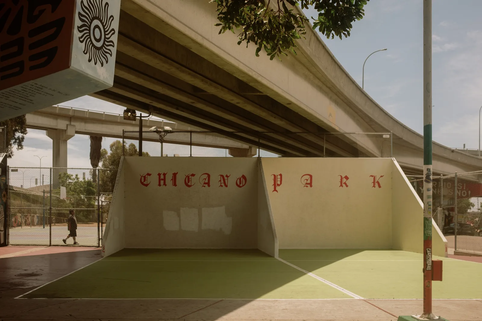 Court walls lettered CHICANO PARK beneath a freeway overpass, Barrio Logan, San Diego