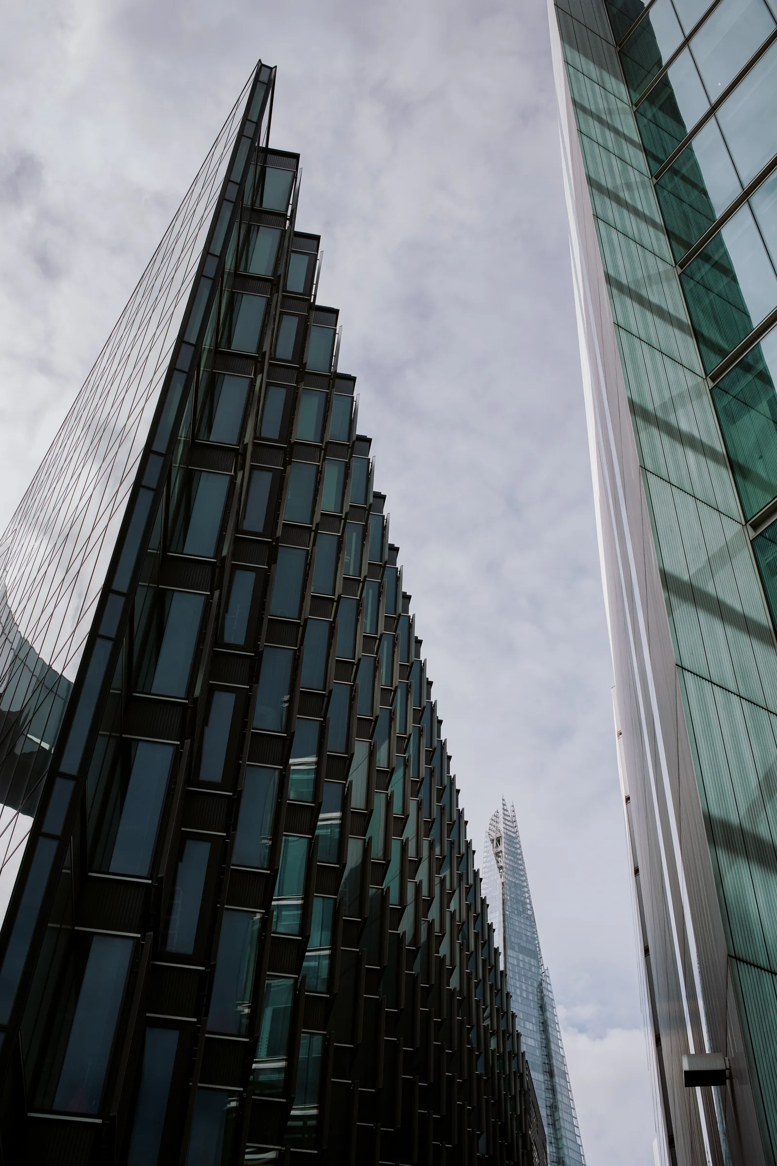 Looking up between two glass towers toward the Shard, London