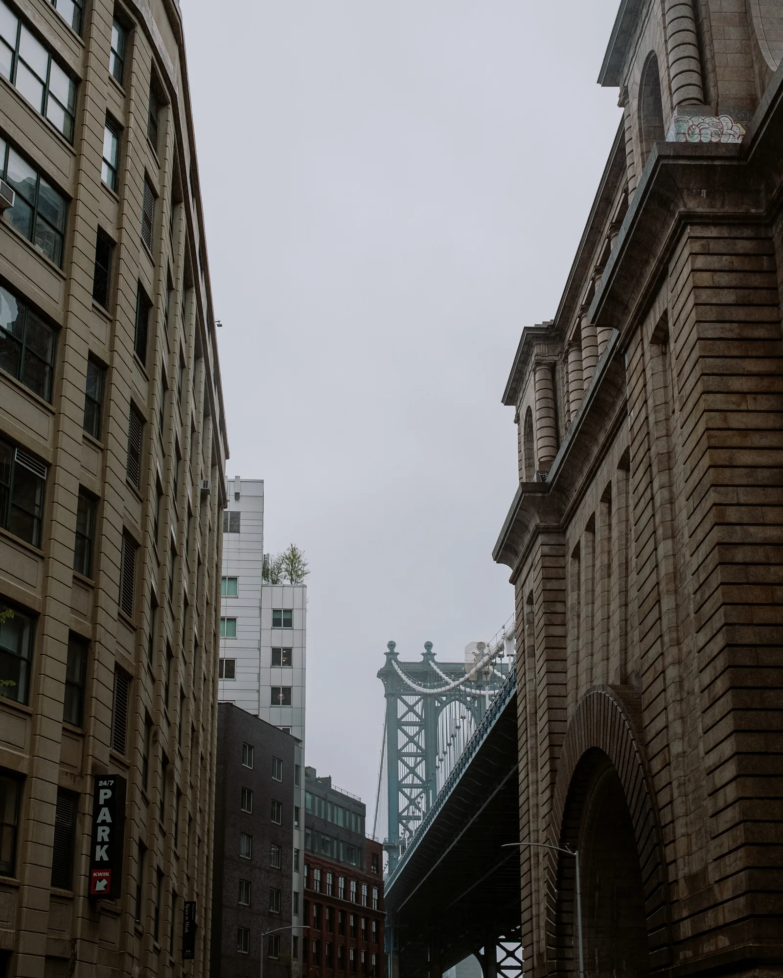 Manhattan Bridge tower between brick warehouses in DUMBO, Brooklyn