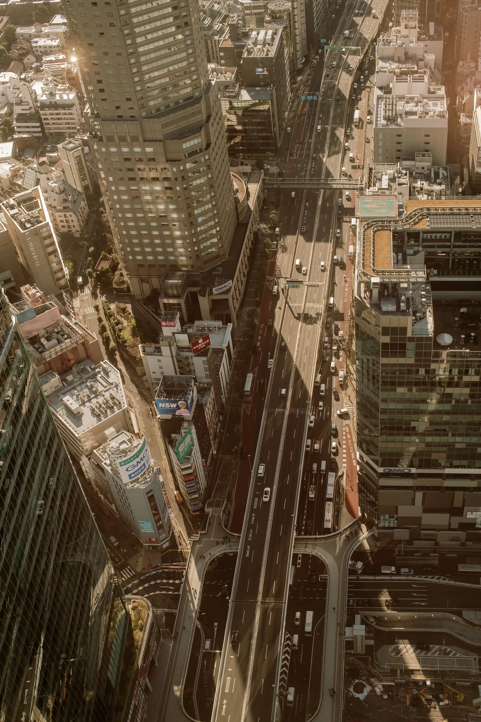 Tokyo streets and buildings seen from directly above, a busy road cutting through