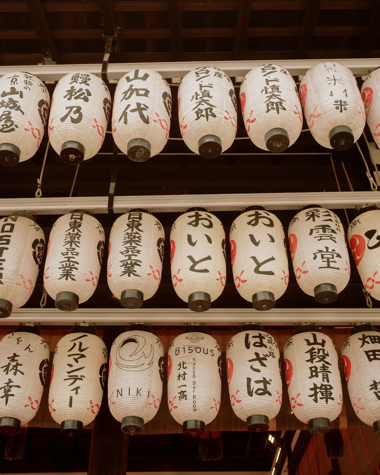 Rows of white paper lanterns painted with names in Japanese, Kyoto
