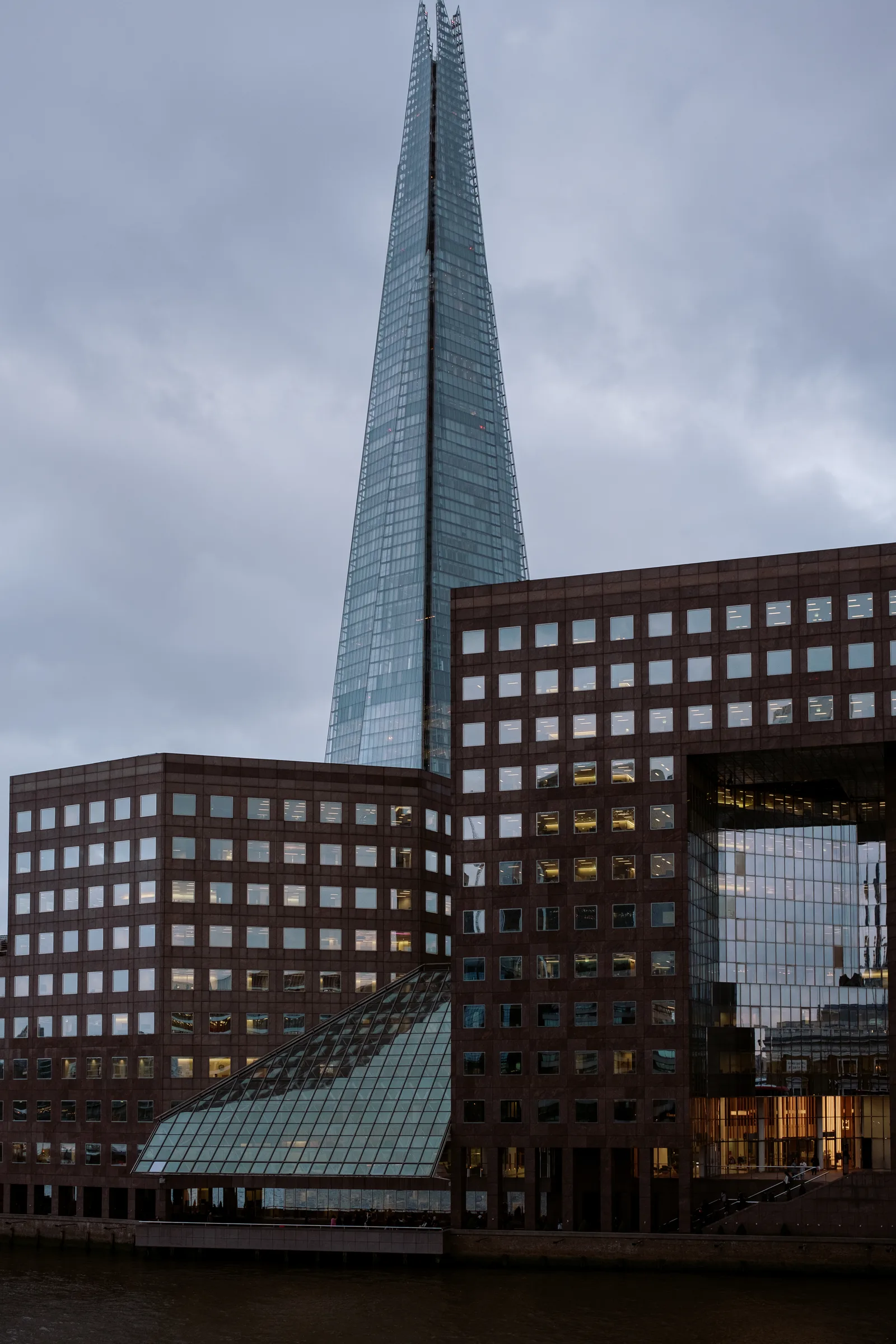 The Shard above brick-and-glass office buildings on the Thames, London