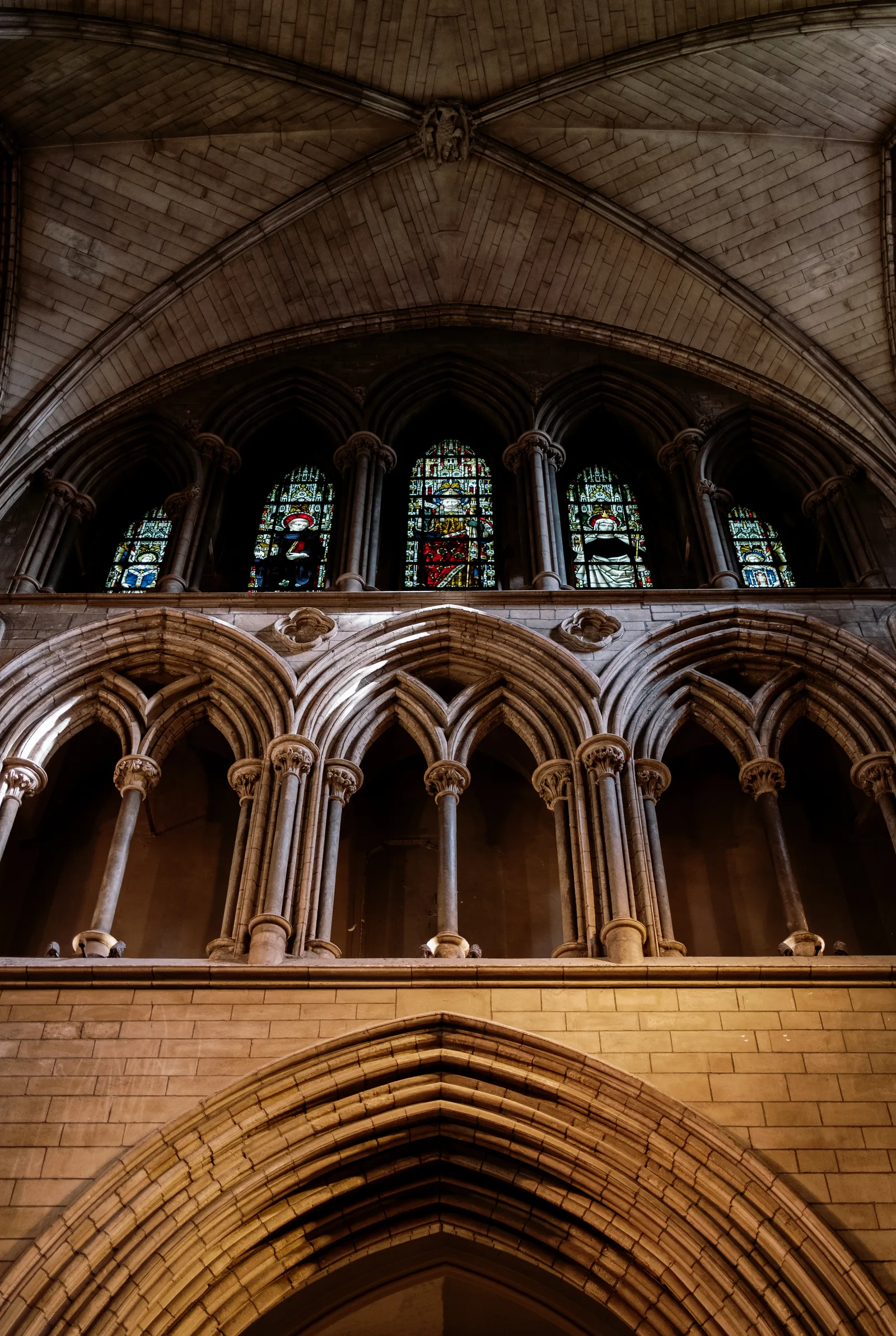 Gothic arches and small stained-glass windows in the vaulted ceiling of a Dublin church