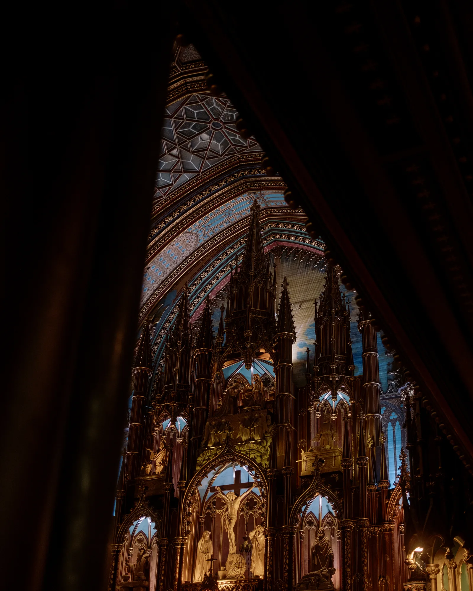 Notre-Dame Basilica's blue vaulted altar glimpsed past a dark curtain, Montreal