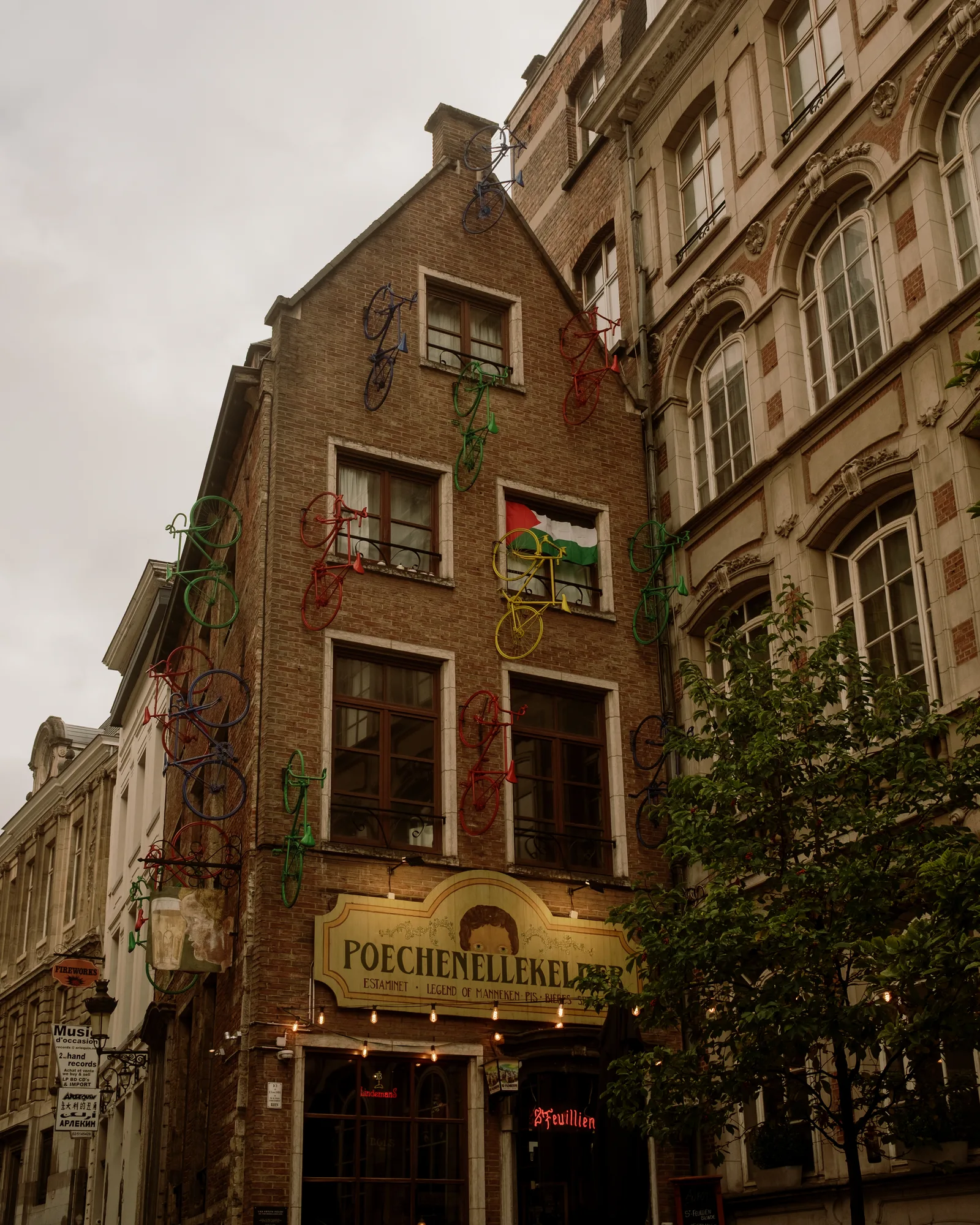 Stepped brick corner building with a café sign above the entrance, Brussels on an overcast day