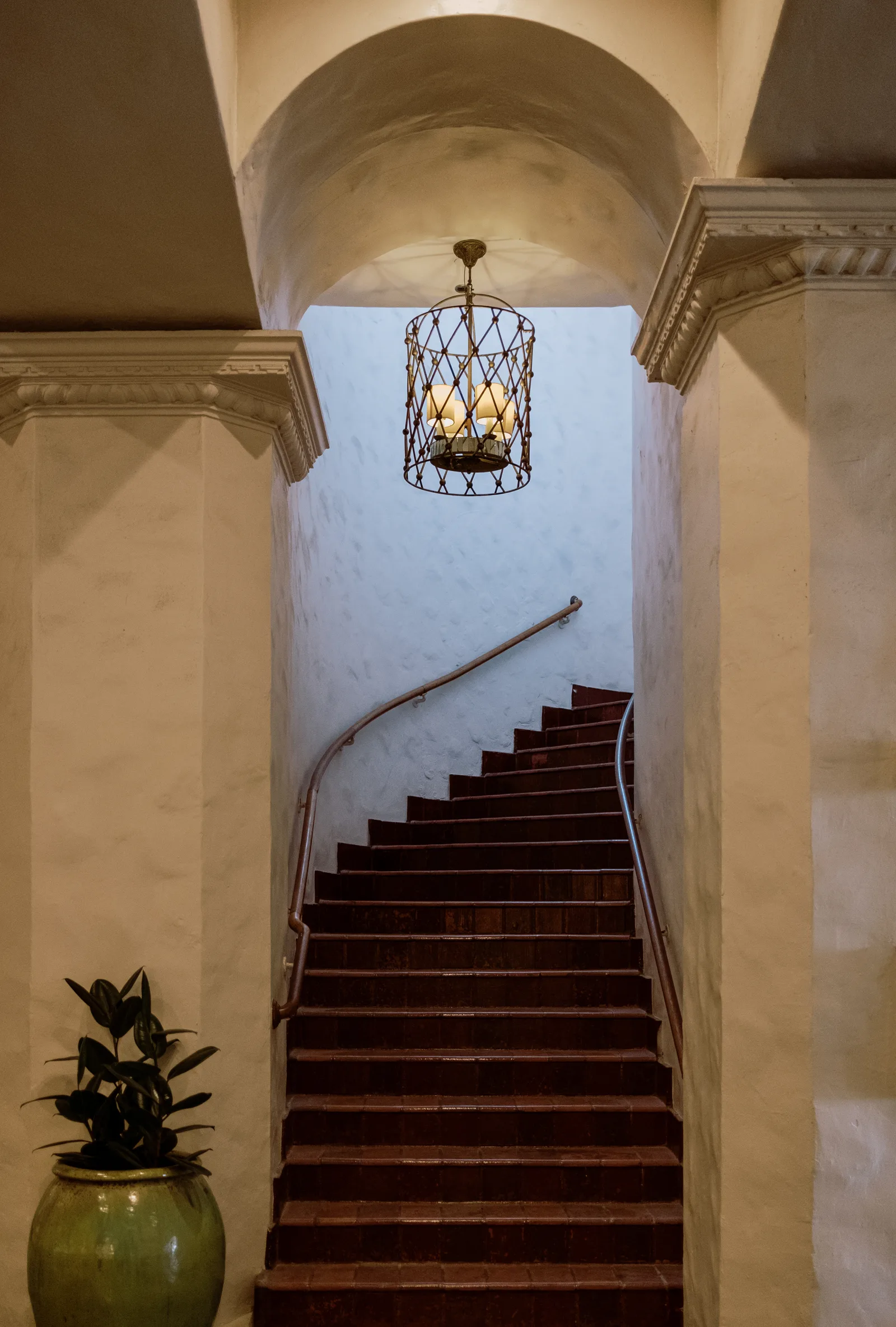 Staircase beneath a hanging lantern between cream columns, Waikiki