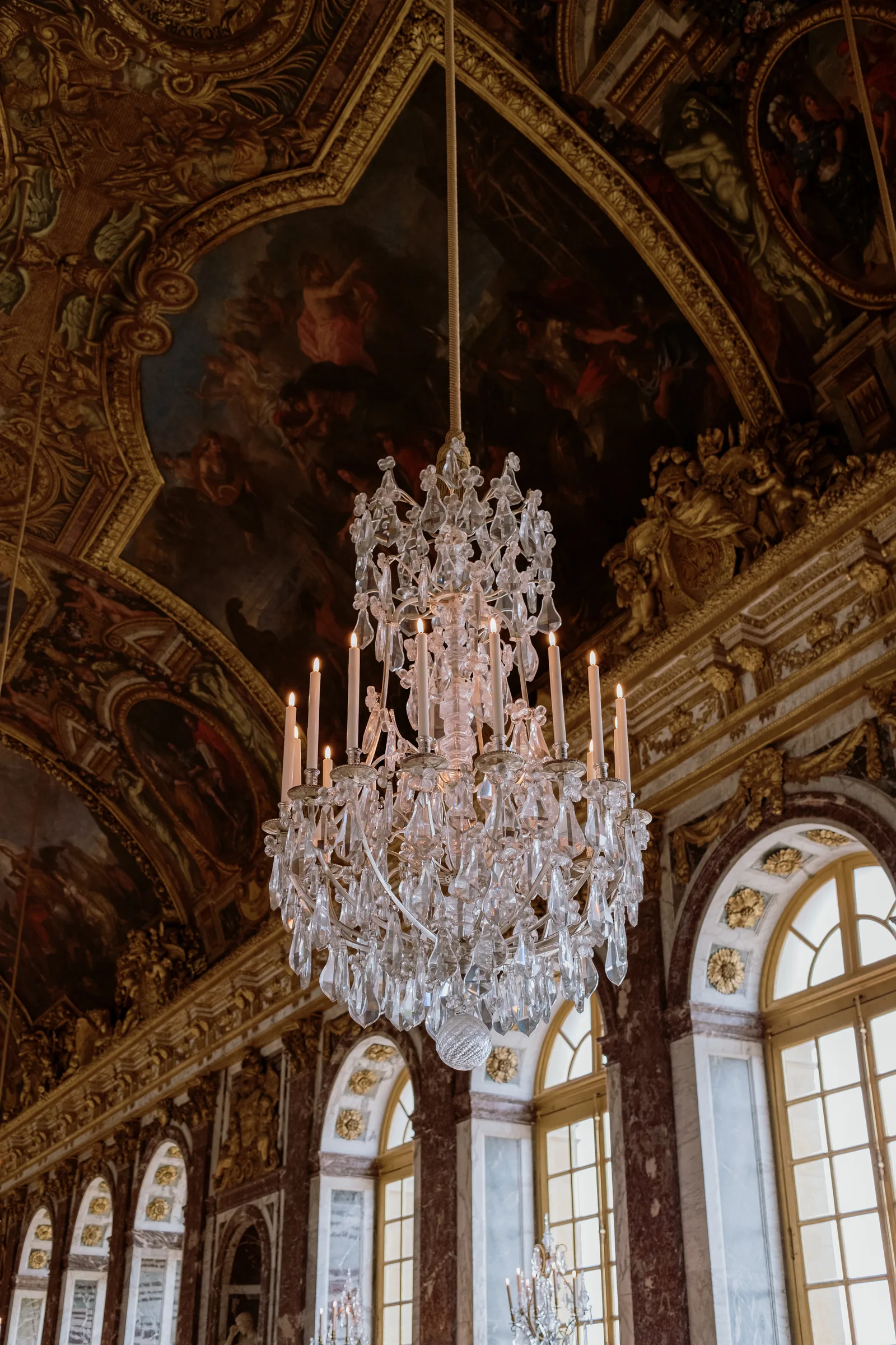 Crystal chandelier hanging beneath the painted ceiling of the Hall of Mirrors, Versailles