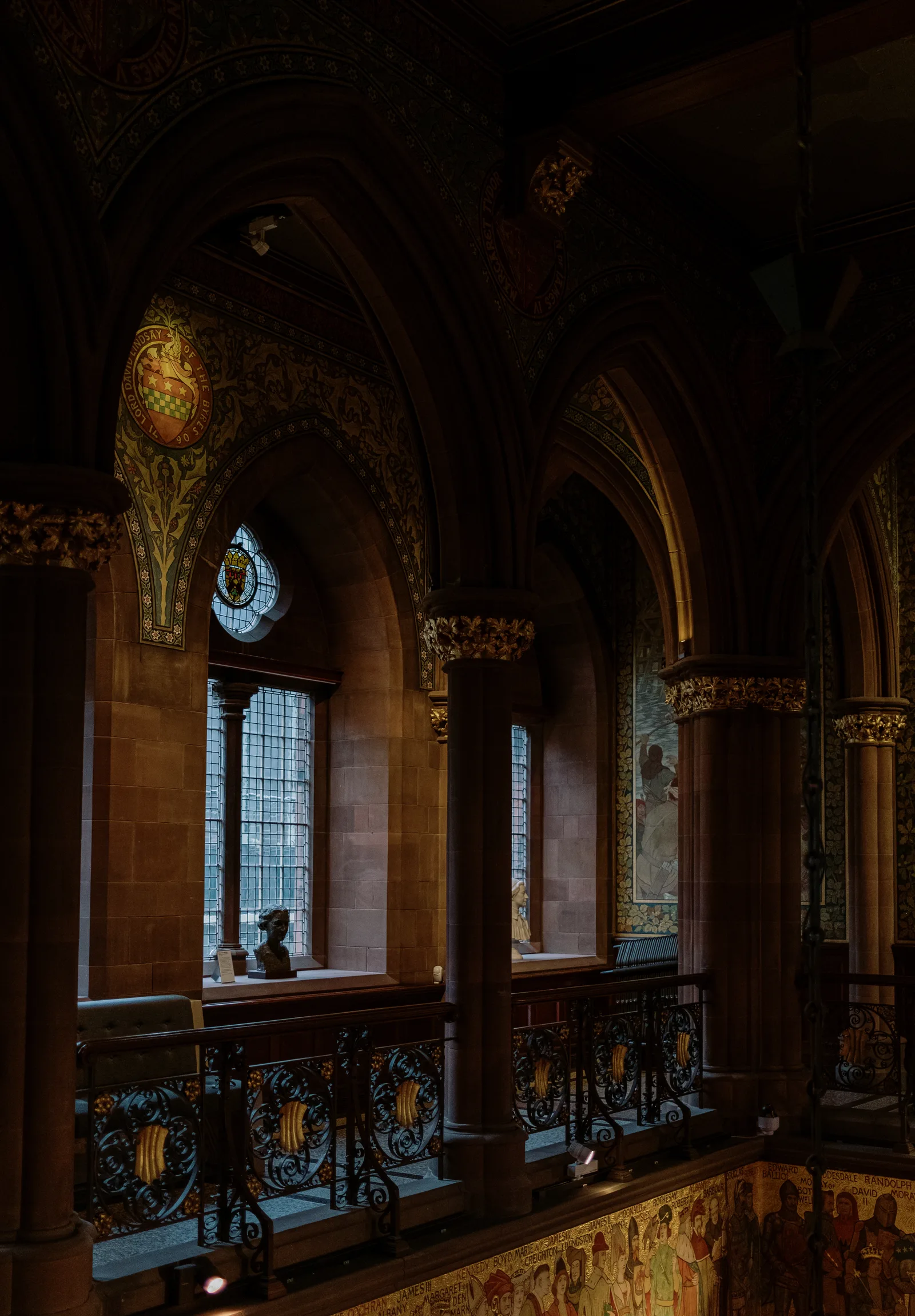 Arched gallery with a decorated ceiling and iron railings above a staircase, Edinburgh