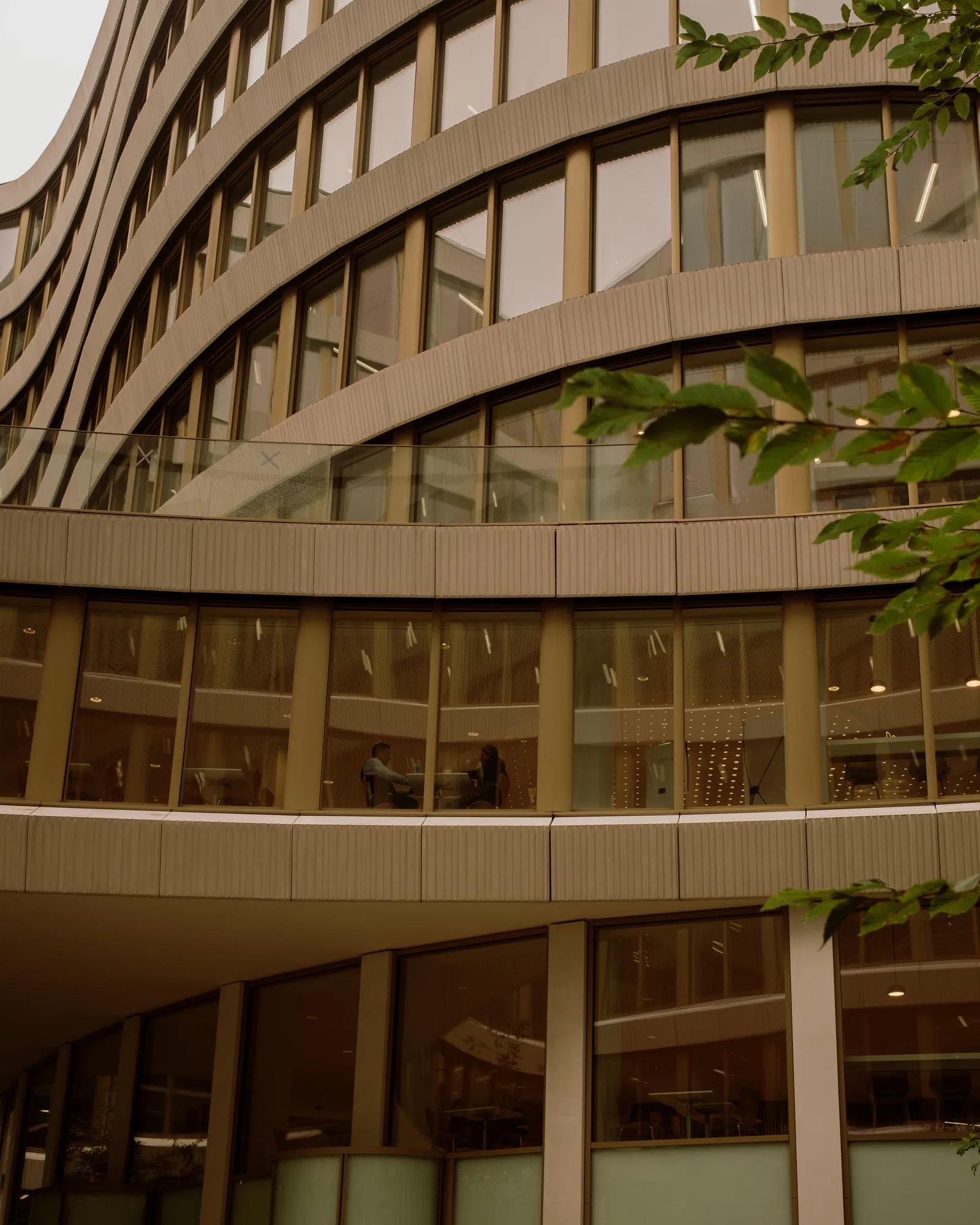 Curved glass and stone office building with rounded balconies, Brussels
