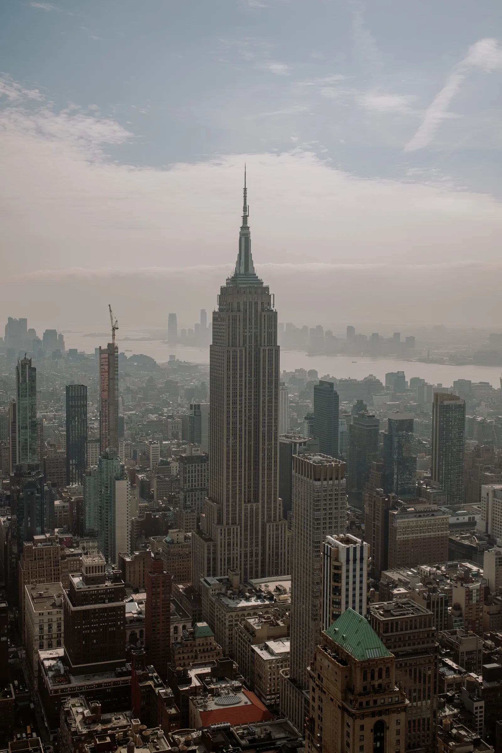 Empire State Building rising above Manhattan rooftops in hazy light