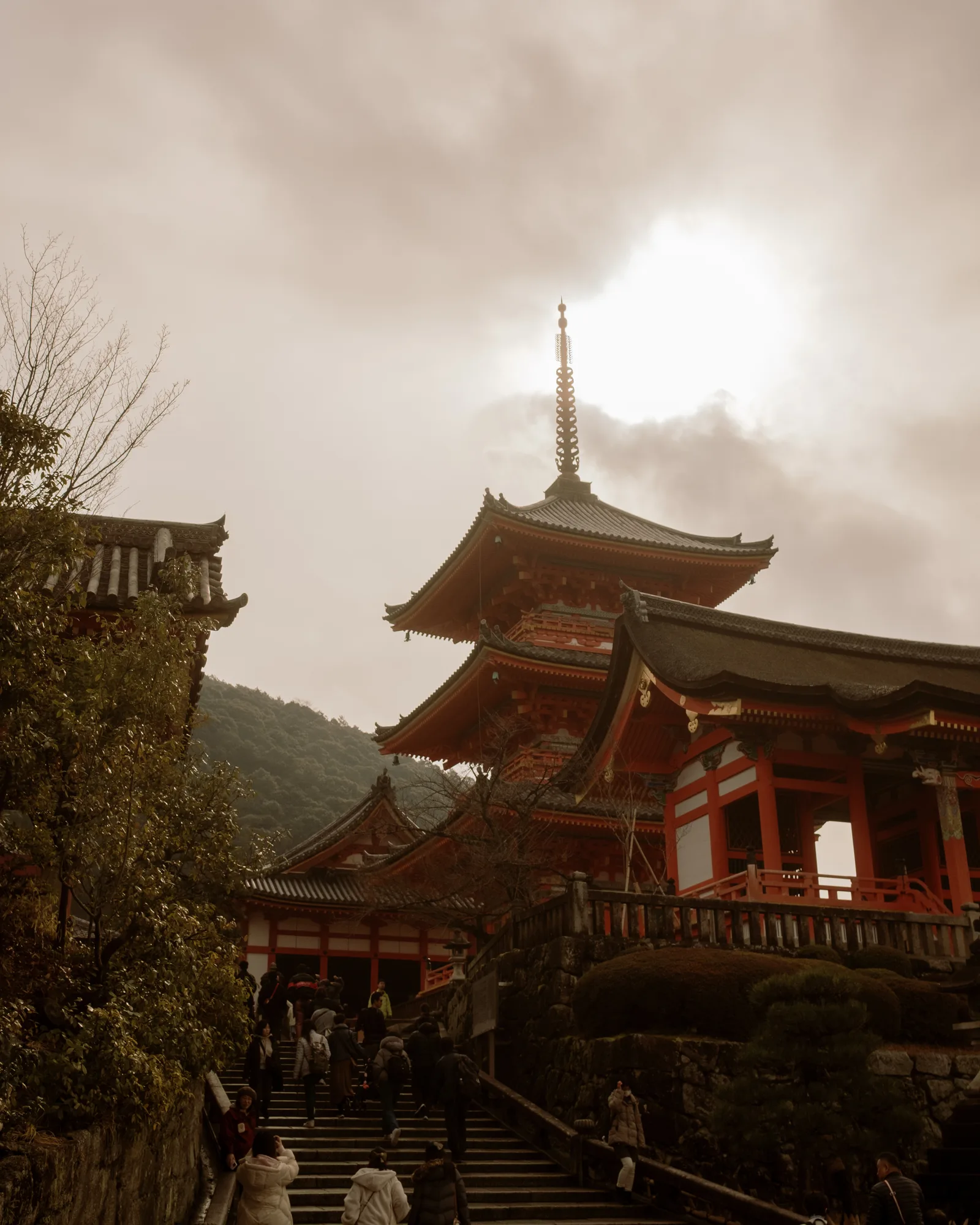 Red pagoda and temple halls above stone steps at Kiyomizu-dera, Kyoto