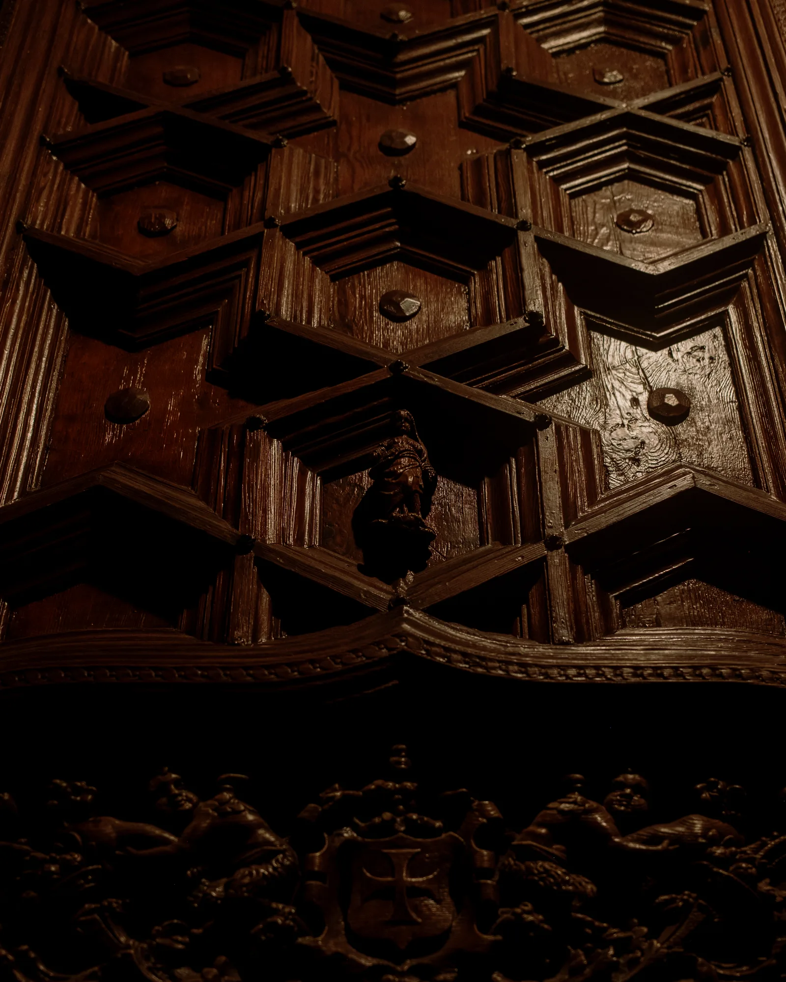 Dark carved wooden door with geometric coffered panels, Barcelona