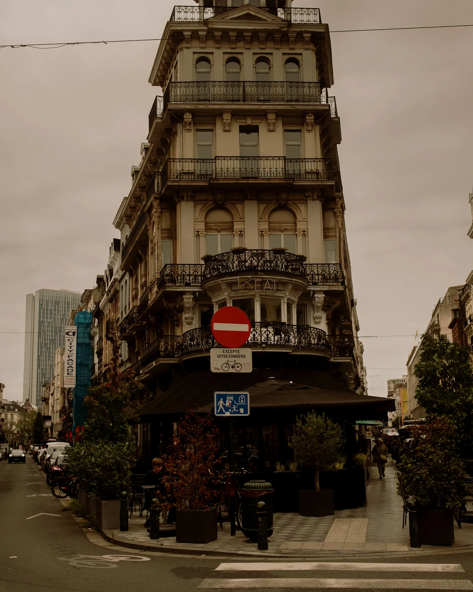 Corner building with iron balconies and a no-entry sign at a Brussels intersection