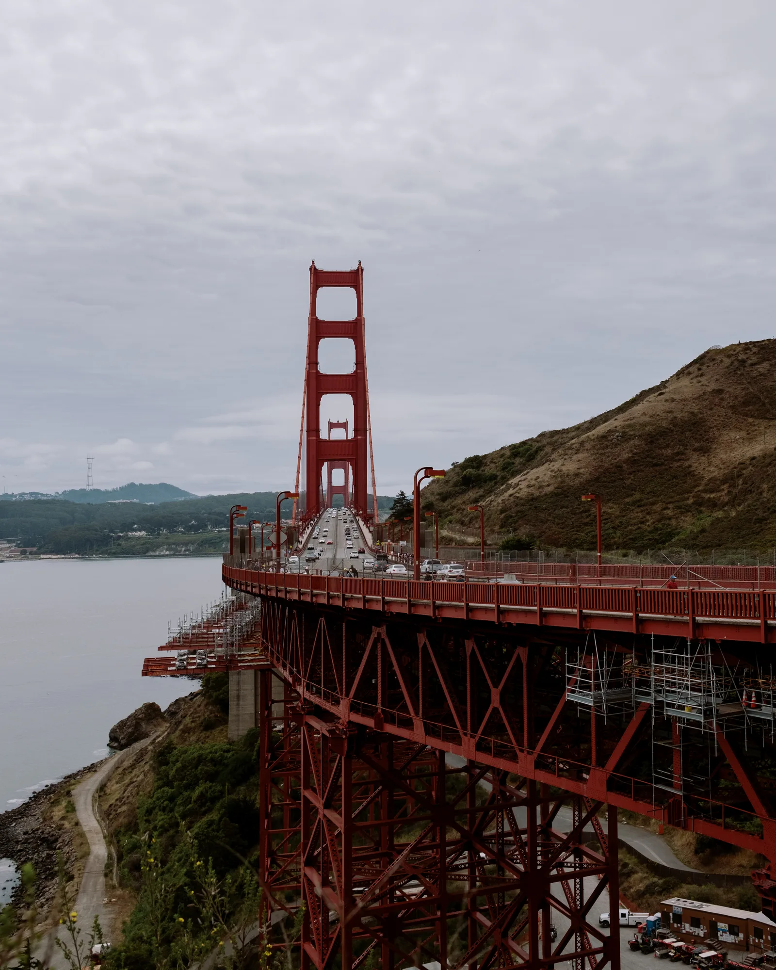 Golden Gate Bridge tower rising above the road curving along the Marin headland
