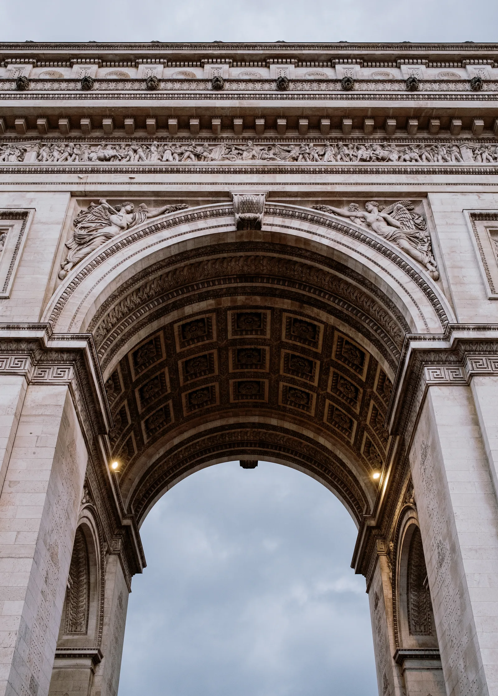 Arc de Triomphe seen from beneath its arch against a cloudy sky, Paris