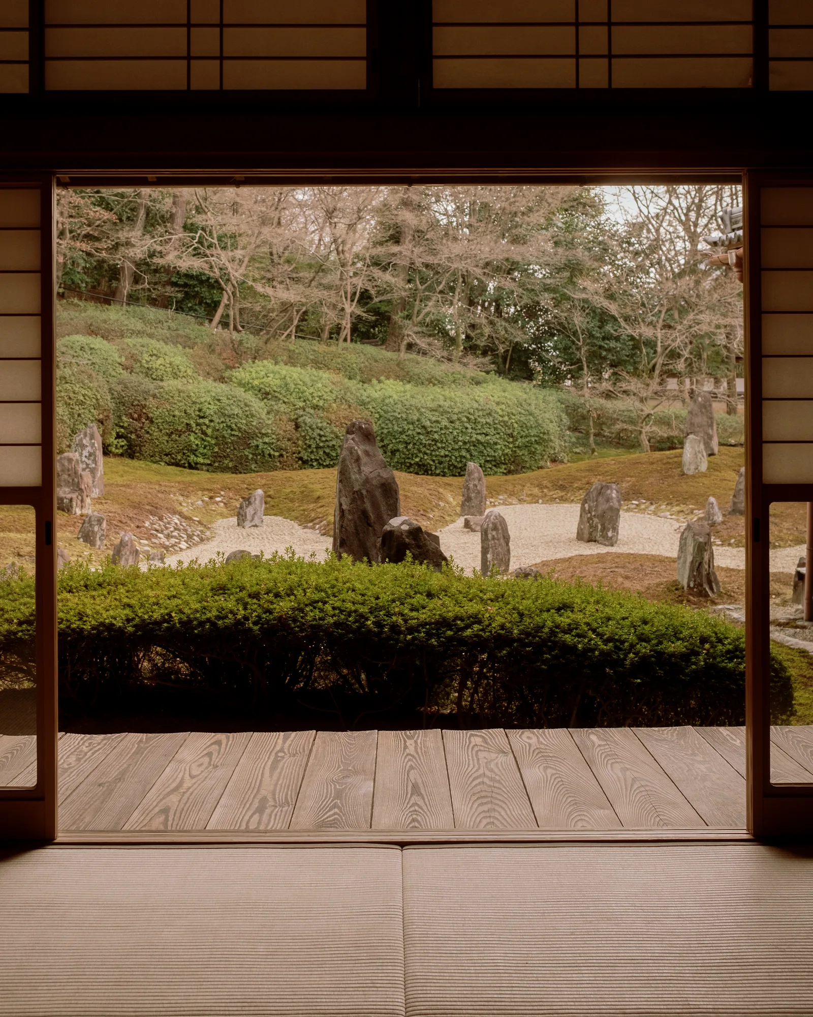 View through an open wooden frame of a rock and gravel garden, Kyoto