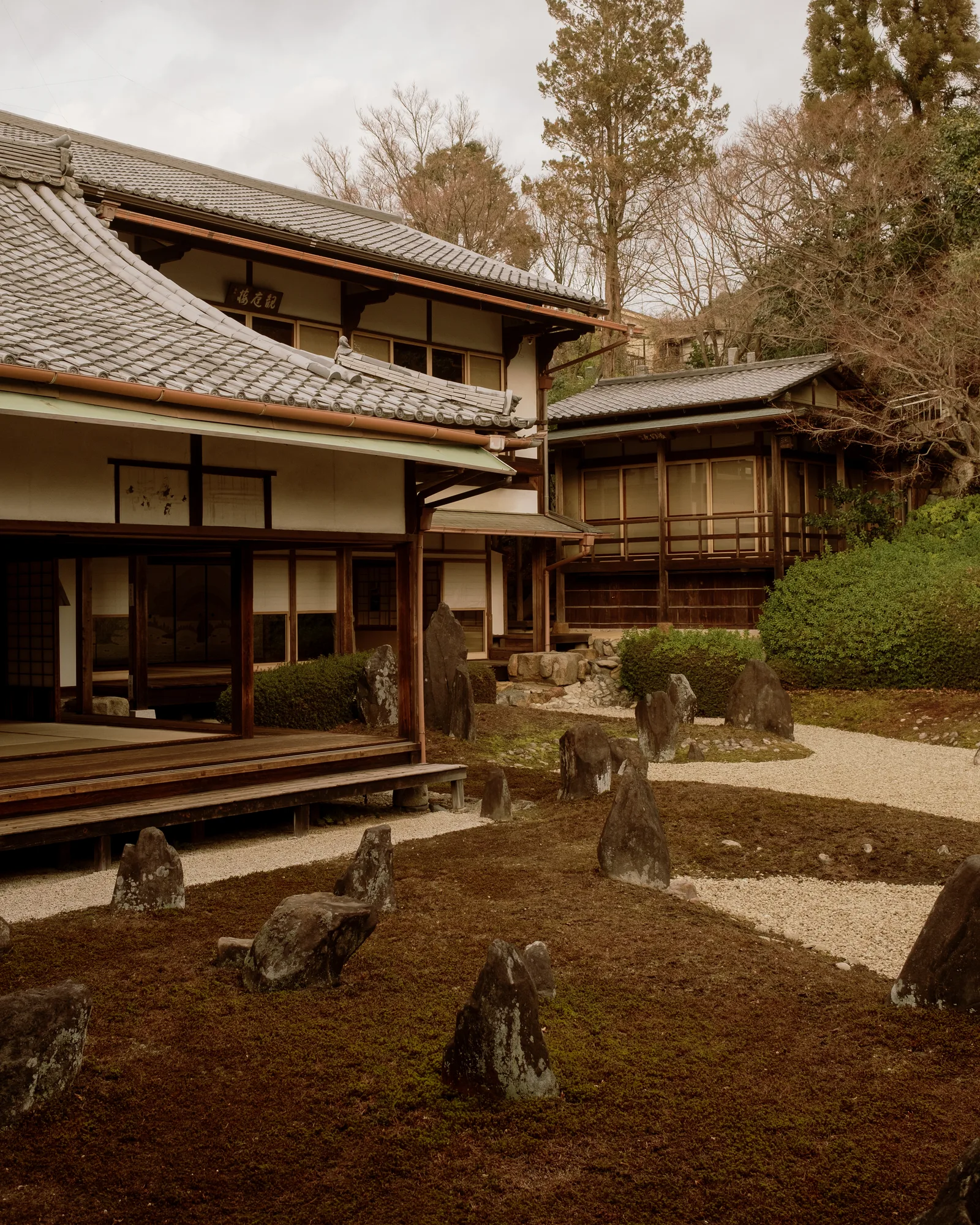 Moss and stone garden beside a traditional wooden house, Kyoto