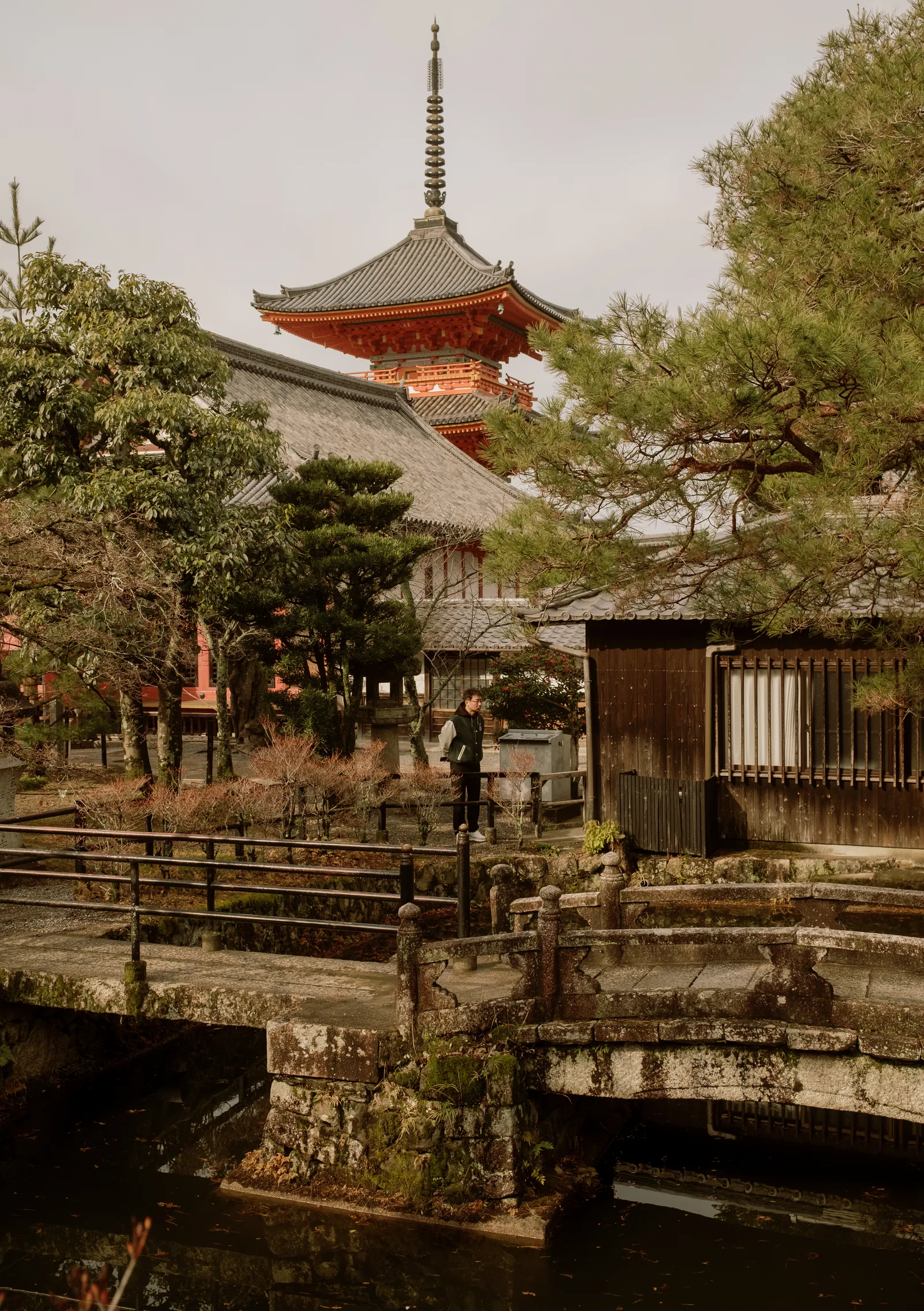 Red pagoda above a temple garden and stone bridge at Kiyomizu-dera, Kyoto
