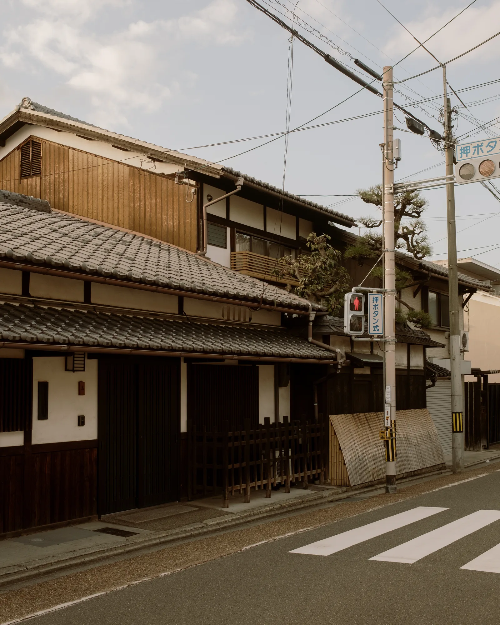 Kyoto street with traditional wooden houses, overhead wires and a crosswalk