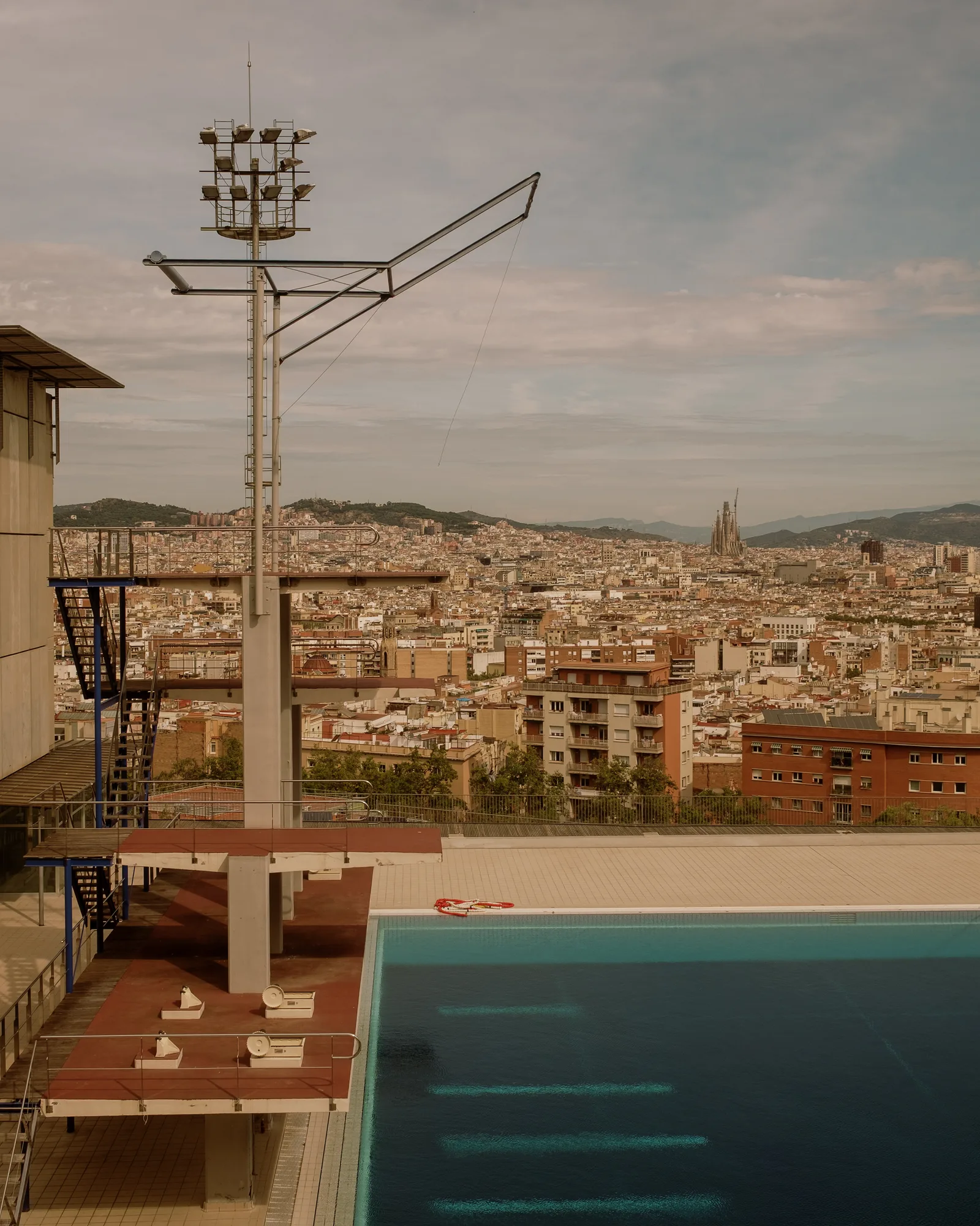 Diving platform and empty pool above the rooftops and coast of Barcelona
