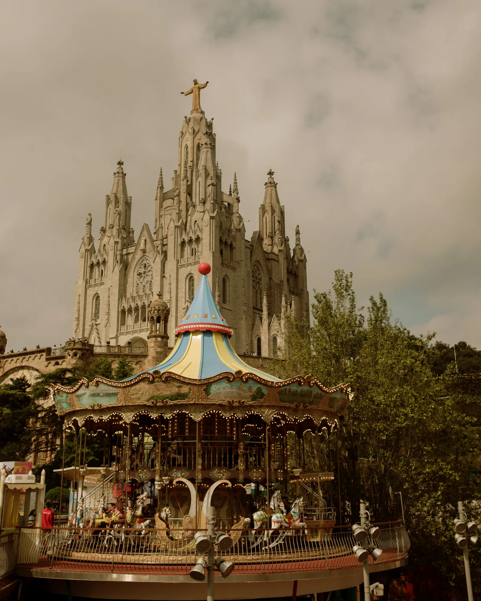 Tibidabo church on its hilltop behind a colorful vintage carousel, Barcelona